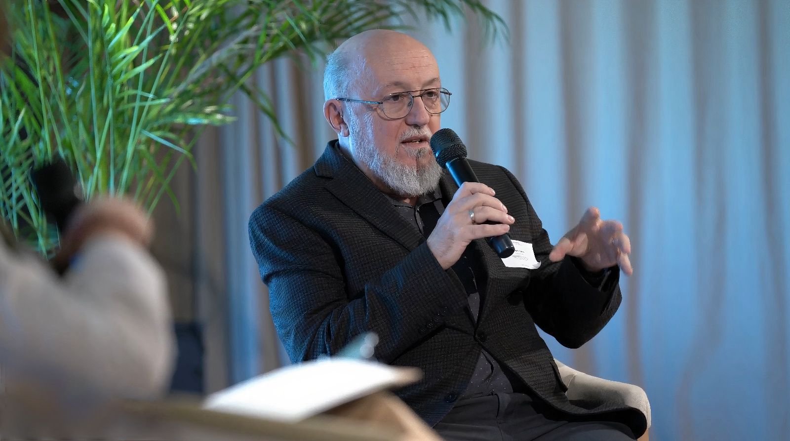Speaker explaining a point with a microphone